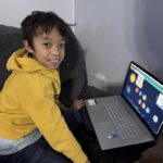 Xavier using laptop to help with his studies